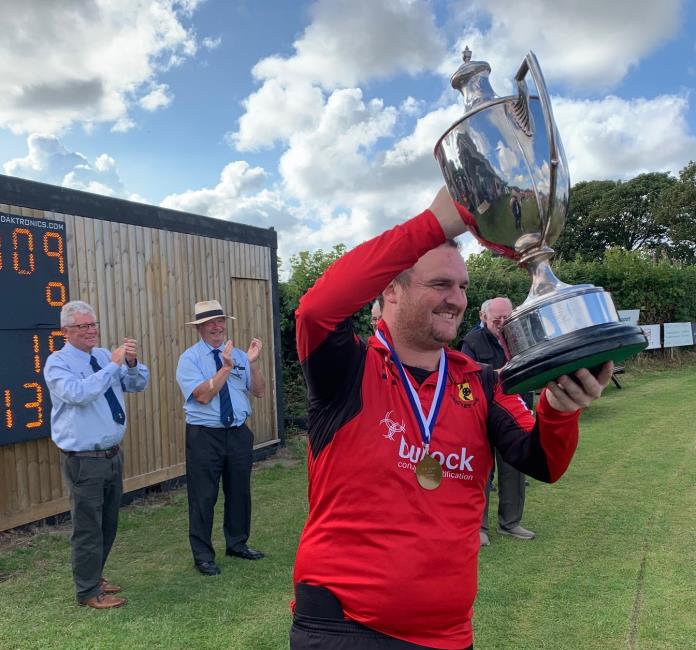 Rhys Davies raises the magnificent trophy aloft